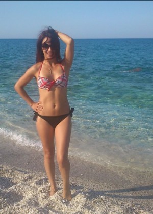 Slender Greek woman in a bikini on the beach